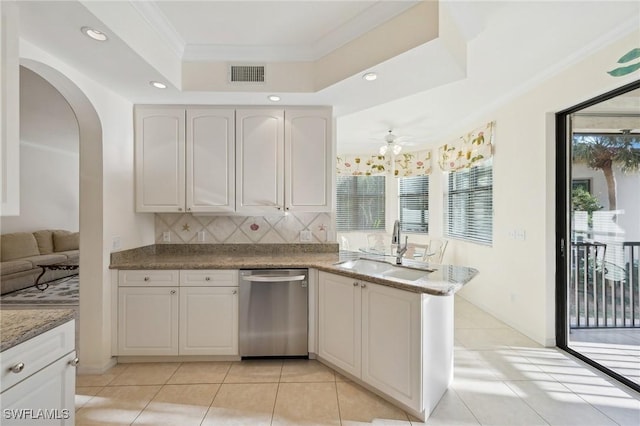 kitchen featuring white cabinetry, sink, stainless steel dishwasher, a raised ceiling, and crown molding