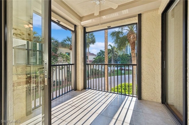 unfurnished sunroom featuring ceiling fan