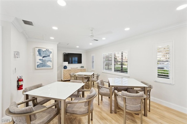 dining space featuring crown molding, light hardwood / wood-style flooring, and ceiling fan