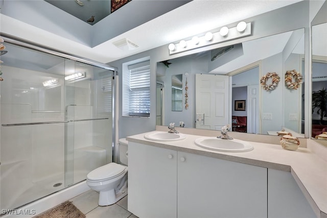 bathroom with vanity, tile patterned floors, a shower with door, and toilet