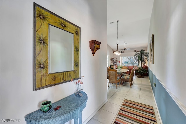 hallway featuring light tile patterned flooring and high vaulted ceiling