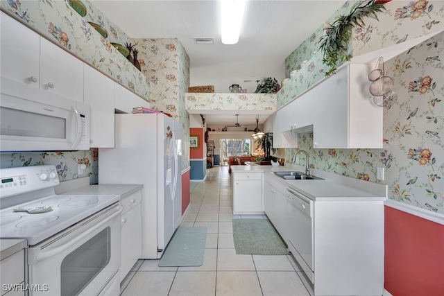 kitchen with white cabinetry, sink, white appliances, and light tile patterned flooring