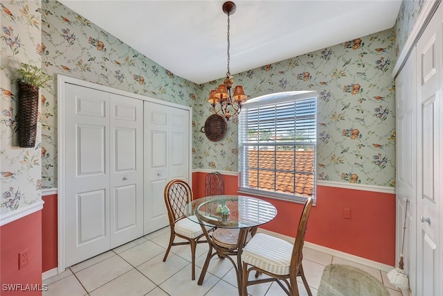 tiled dining room with a chandelier