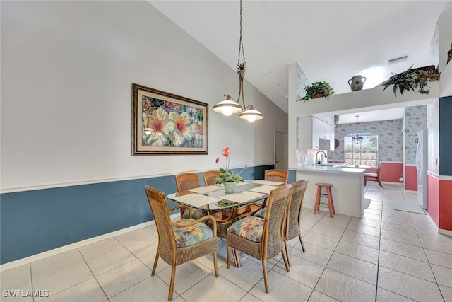 dining area featuring light tile patterned floors, high vaulted ceiling, and sink