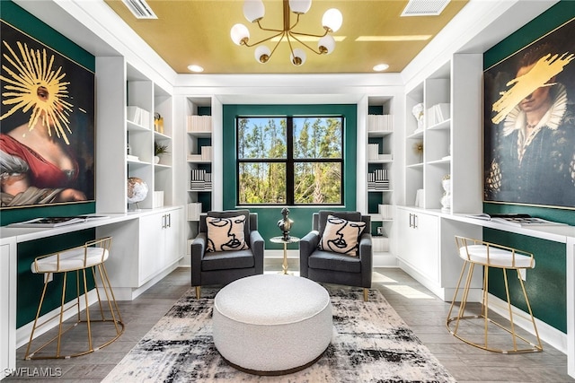 living area featuring visible vents, an inviting chandelier, and wood finished floors