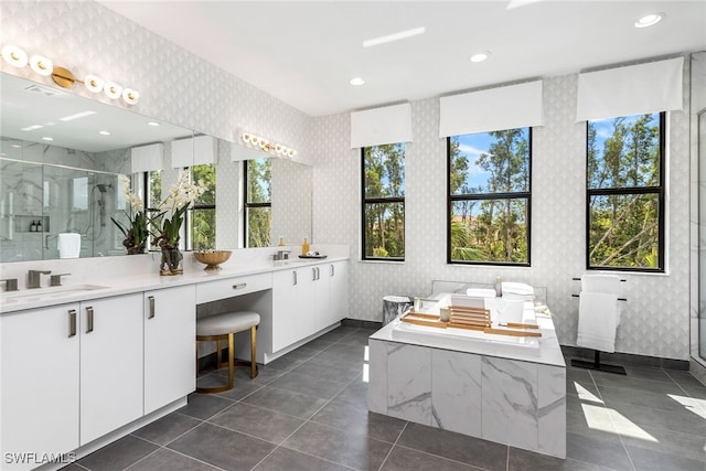 bathroom with a stall shower, wallpapered walls, and a sink