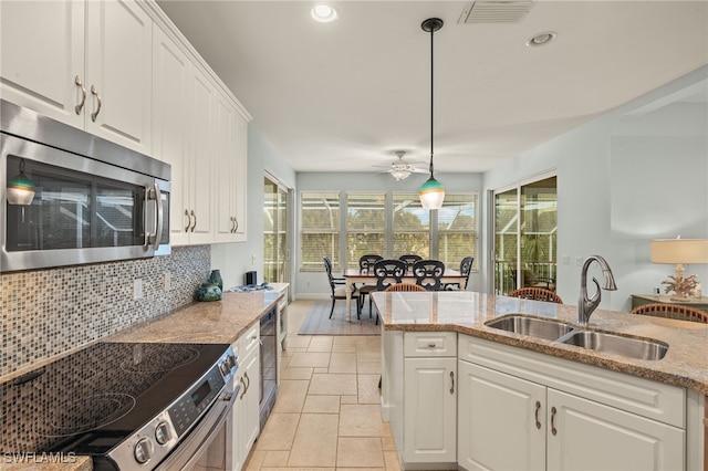 kitchen with pendant lighting, appliances with stainless steel finishes, sink, and white cabinets