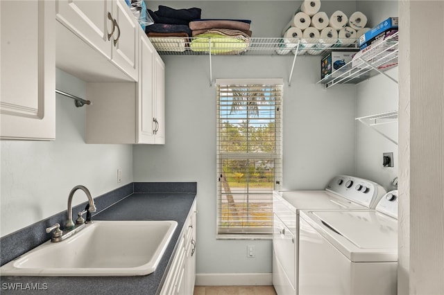 laundry room with sink, washing machine and dryer, and cabinets