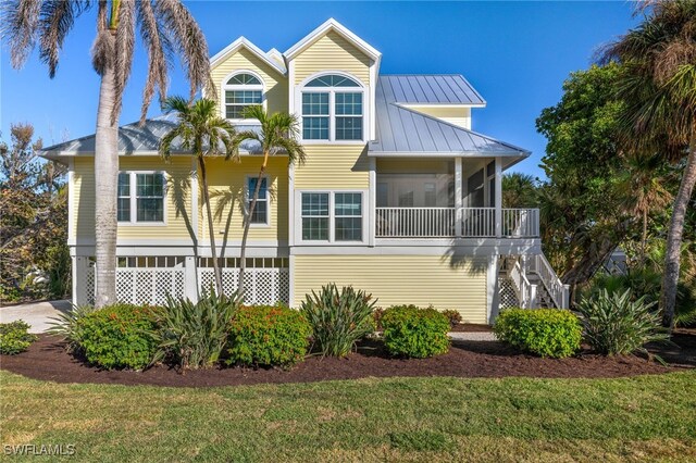 view of front of home featuring a sunroom and a front lawn