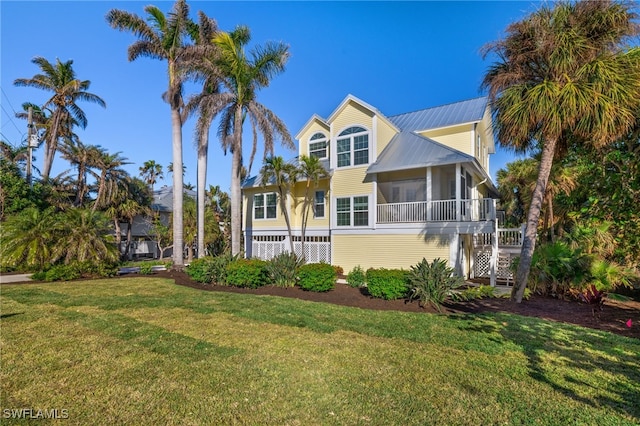 view of front facade with a front yard and a sunroom