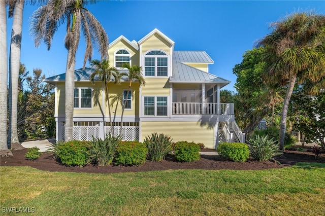 view of front of home featuring a sunroom and a front yard