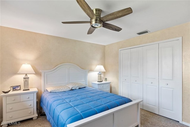 bedroom with light carpet, ceiling fan, visible vents, and a closet