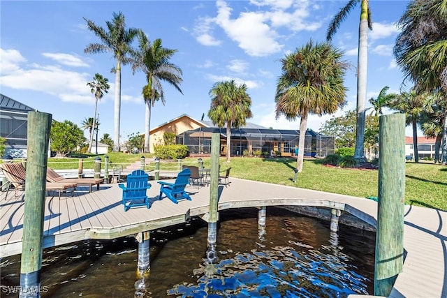 dock area featuring a water view, a lanai, and a lawn