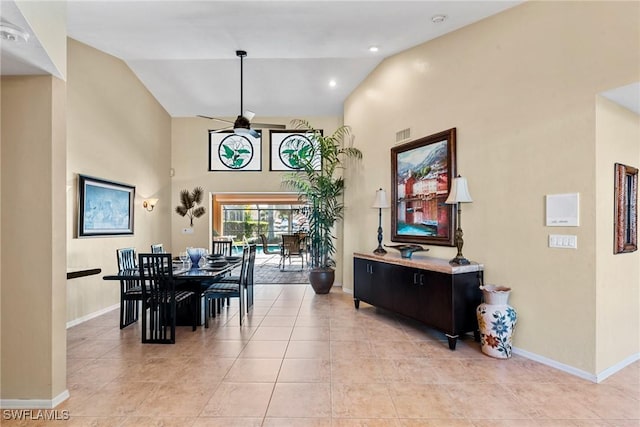 dining area with high vaulted ceiling, baseboards, and light tile patterned flooring