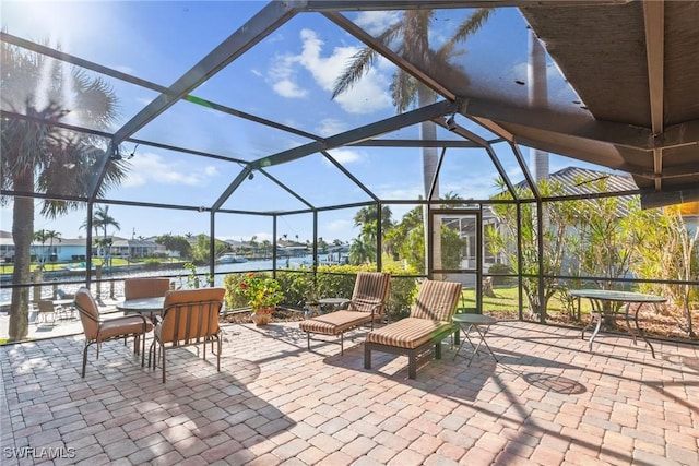 view of patio / terrace with glass enclosure and a water view