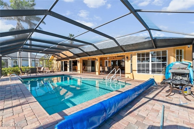 view of pool with a lanai, a patio area, and a covered pool