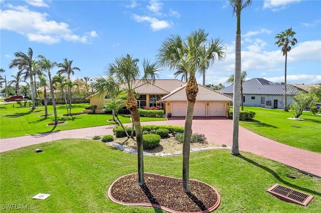 view of front of property with decorative driveway, an attached garage, a tiled roof, and a front lawn