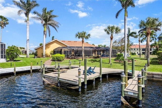 view of dock with a water view, glass enclosure, and a lawn