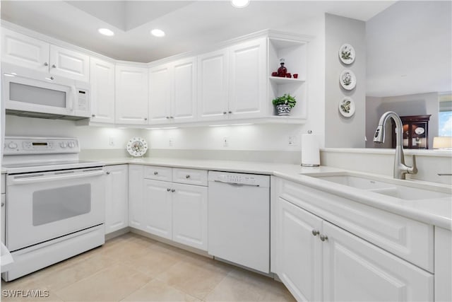 kitchen featuring white appliances, sink, light tile patterned flooring, and white cabinets