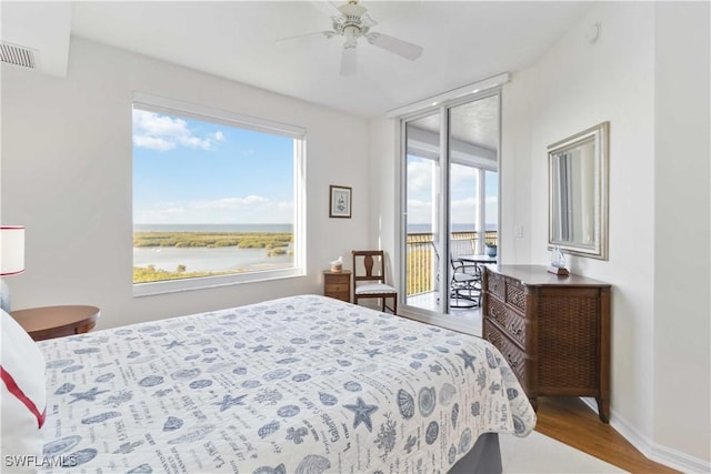 1001 Arbor Lake Dr Unit 1202, Naples, FL 34110 - bedroom featuring multiple windows, access to outside, wood finished floors, and a water view