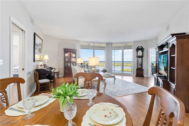 dining space with hardwood / wood-style flooring and floor to ceiling windows