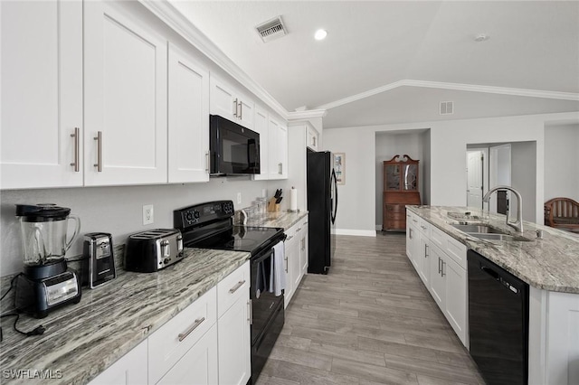 kitchen featuring sink, black appliances, white cabinets, and light stone countertops