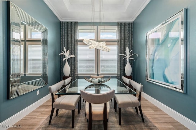 dining space with hardwood / wood-style floors and ornamental molding