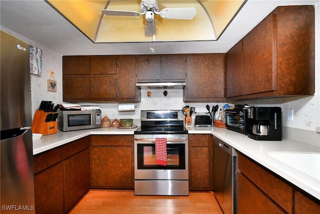 kitchen featuring sink, stainless steel appliances, light hardwood / wood-style floors, and ceiling fan