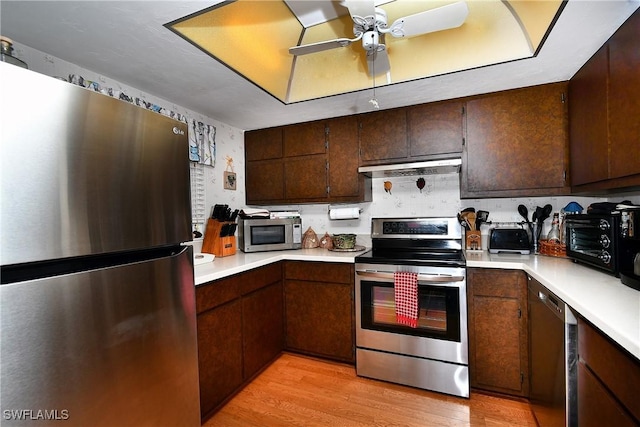 kitchen with dark brown cabinetry, ceiling fan, appliances with stainless steel finishes, and light hardwood / wood-style floors