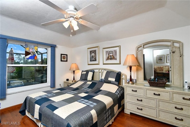 bedroom featuring dark hardwood / wood-style floors, a textured ceiling, and ceiling fan