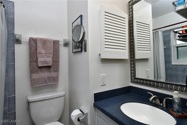 bathroom featuring vanity, a shower with shower curtain, and toilet