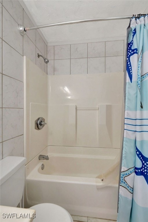 bathroom with shower / bath combo, tile walls, and toilet