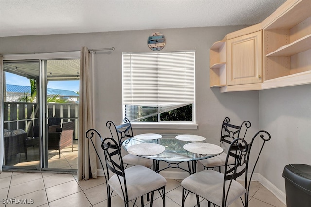 dining room with light tile patterned flooring and a textured ceiling