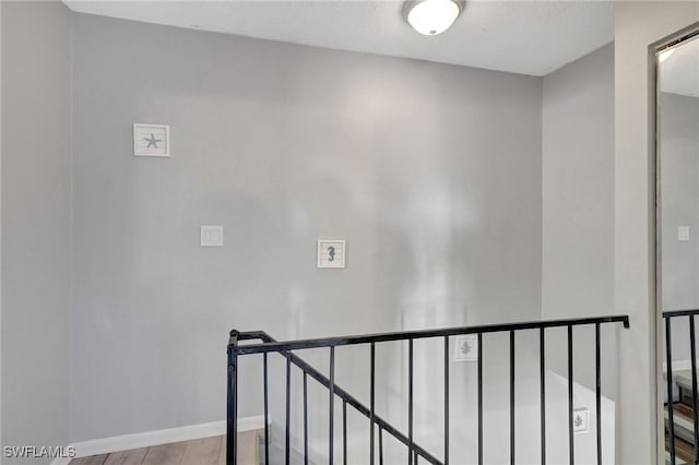 staircase featuring hardwood / wood-style floors and a textured ceiling