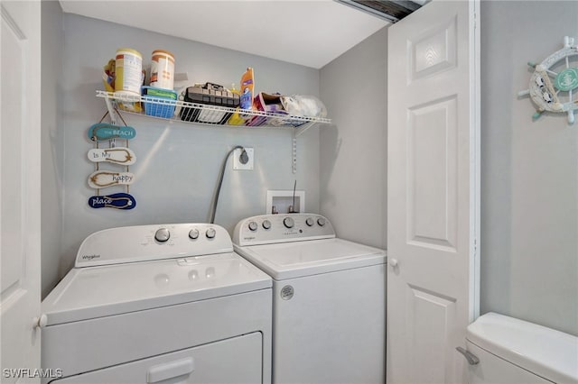 clothes washing area with washing machine and dryer