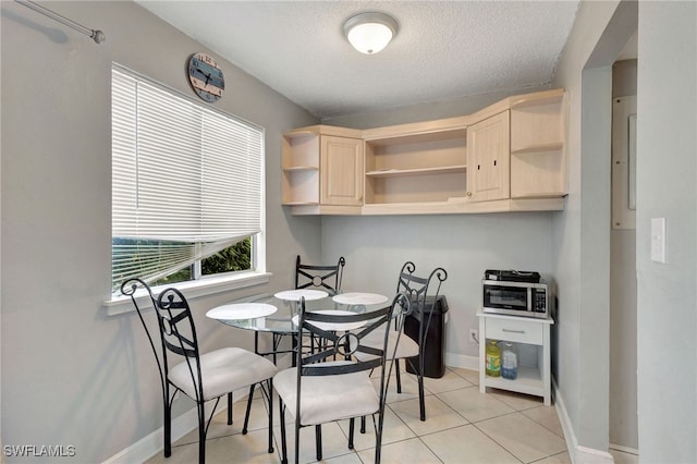 dining area with light tile patterned floors and a textured ceiling