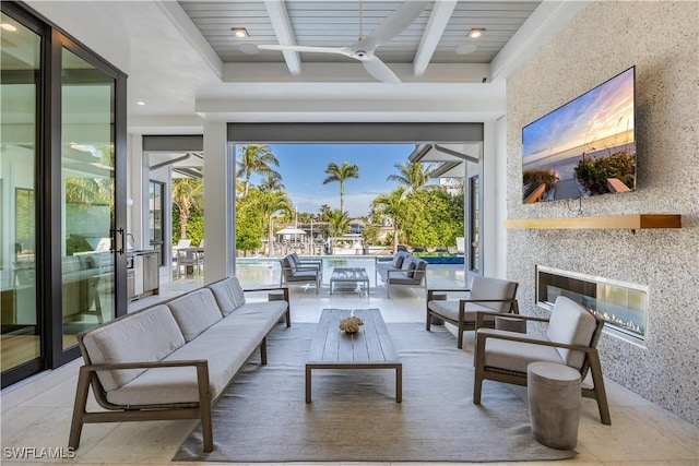 view of patio featuring a ceiling fan and an outdoor living space with a fireplace