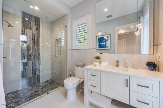 bathroom with vanity, a shower with shower door, decorative backsplash, and toilet