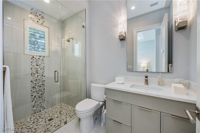 bathroom with vanity, toilet, and a shower with door