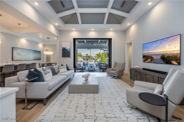 living room with beam ceiling, high vaulted ceiling, and light wood-type flooring