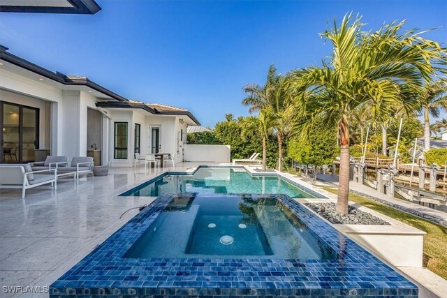 view of swimming pool with a patio and an in ground hot tub