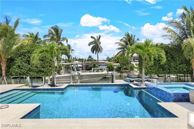 view of swimming pool featuring an in ground hot tub and a water view