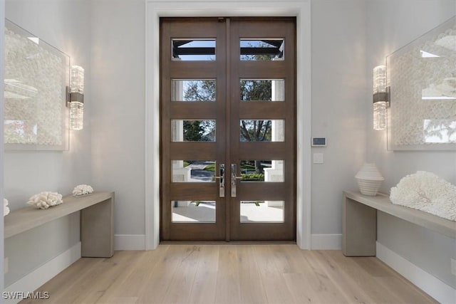 entryway featuring french doors, light wood-type flooring, and baseboards