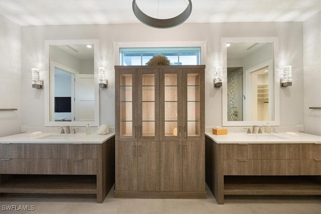 bathroom with a closet, two vanities, and a sink