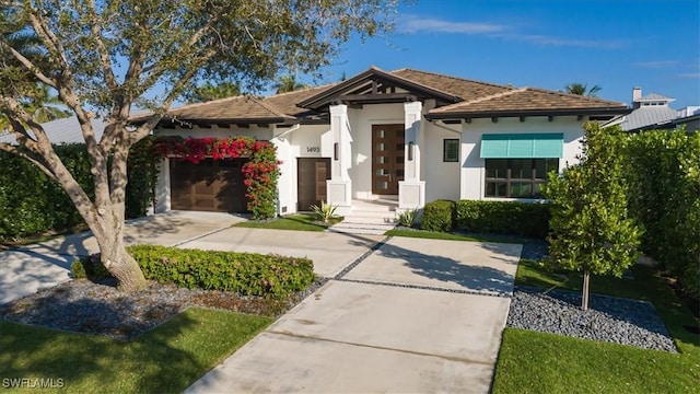 view of front of property featuring a garage, driveway, and stucco siding