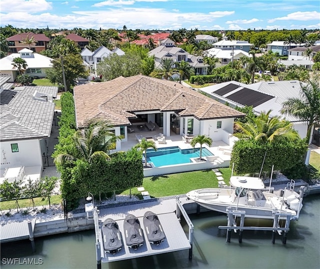 rear view of property with an outdoor pool, a patio, boat lift, a residential view, and a water view