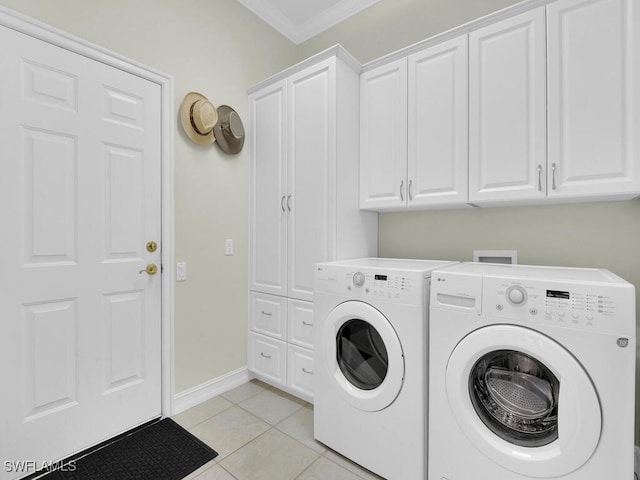 clothes washing area featuring cabinets, light tile patterned flooring, washing machine and clothes dryer, and crown molding