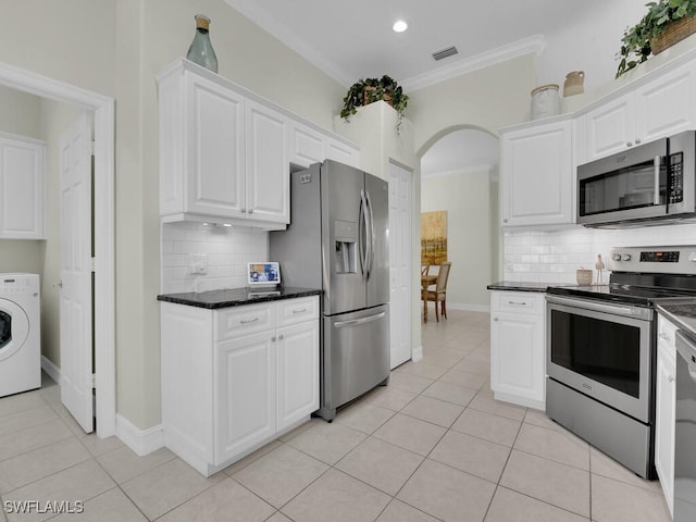 kitchen featuring stainless steel appliances, crown molding, washer / dryer, and white cabinets