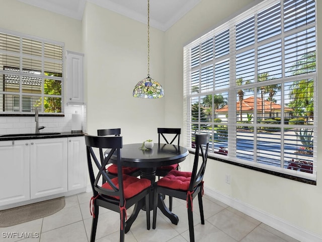 tiled dining room with sink, crown molding, and a healthy amount of sunlight