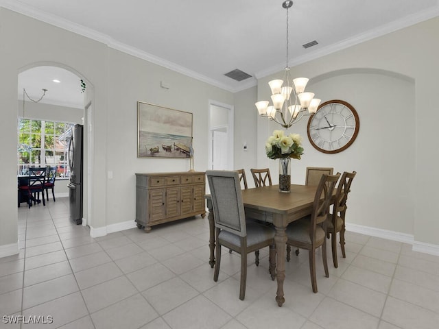 tiled dining space featuring crown molding and an inviting chandelier